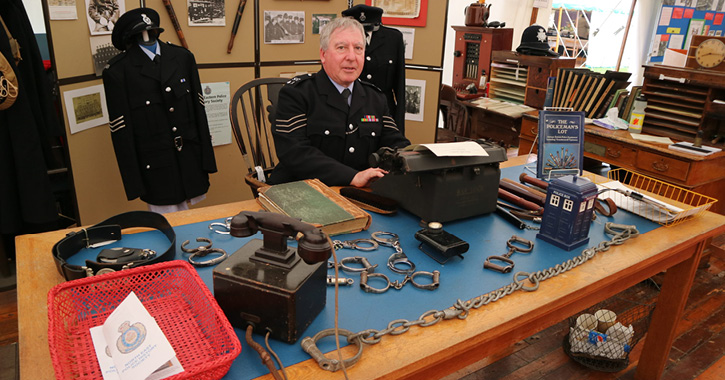 man dressed as police man surrounded by police related objects at Beamish Museum
